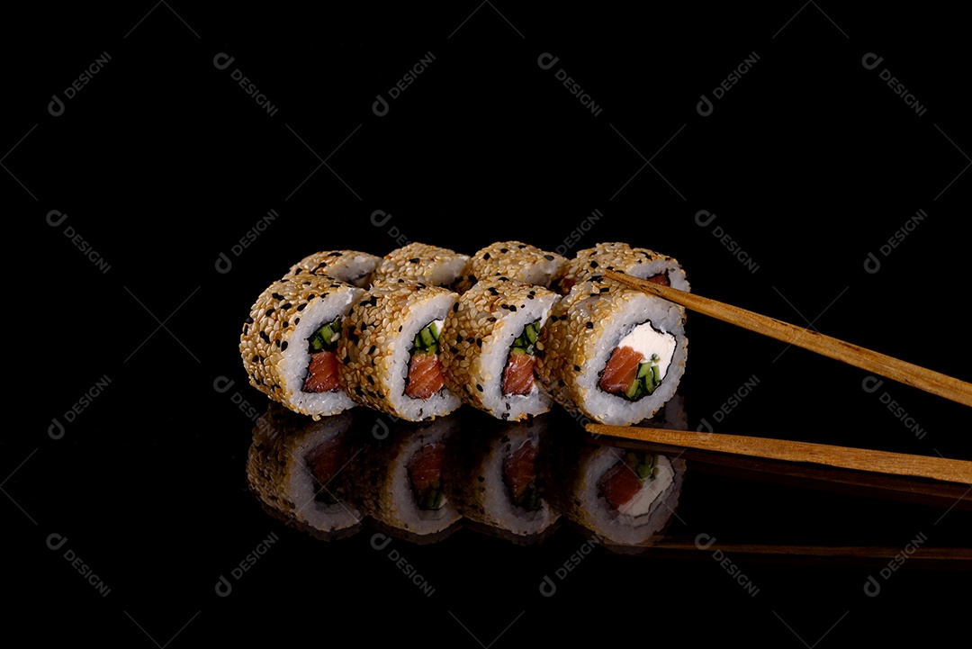 Rolos de sushi lindos e deliciosos frescos em um fundo preto. Elementos da culinária japonesa