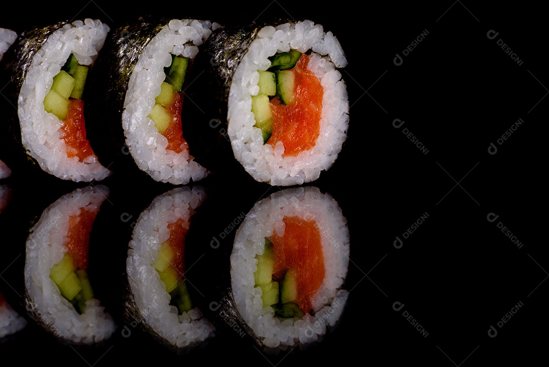 Rolos de sushi lindos e deliciosos frescos em um fundo escuro. Elementos da culinária japonesa