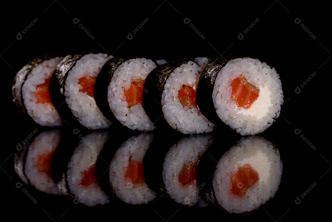 Rolos de sushi lindos e deliciosos frescos em um fundo escuro. Elementos da culinária japonesa