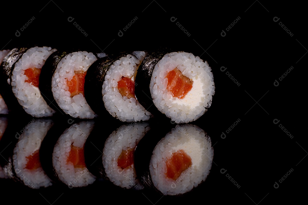 Rolos de sushi lindos e deliciosos frescos em um fundo escuro. Elementos da culinária japonesa