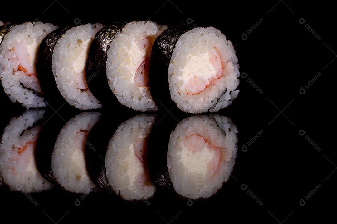Rolos de sushi lindos e deliciosos frescos em um fundo escuro. Elementos da culinária japonesa