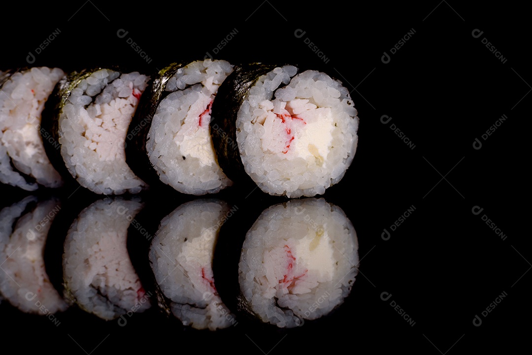 Rolos de sushi lindos e deliciosos frescos em um fundo escuro. Elementos da culinária japonesa