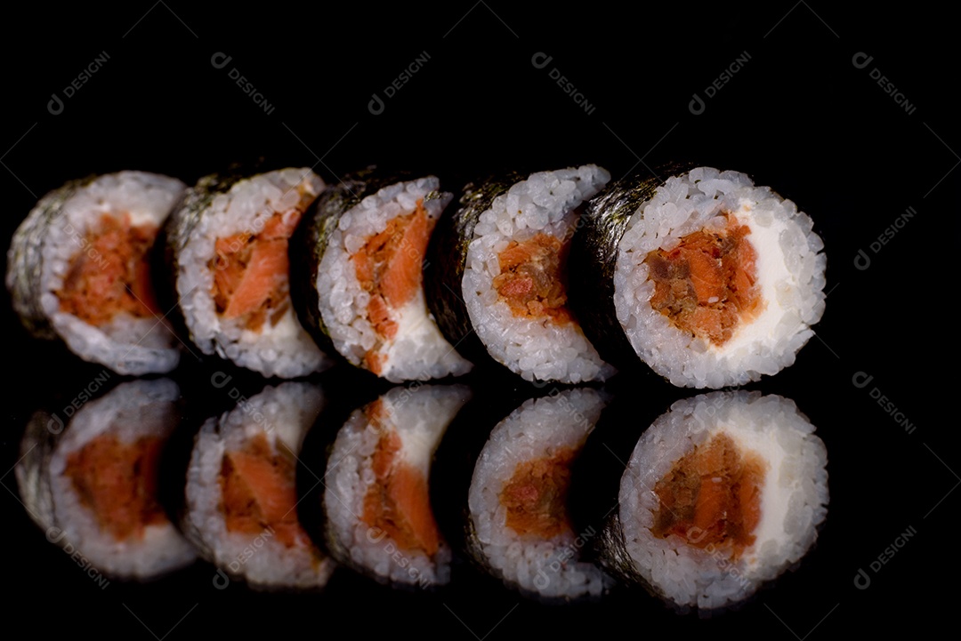 Rolos de sushi lindos e deliciosos frescos em um fundo escuro. Elementos da culinária japonesa
