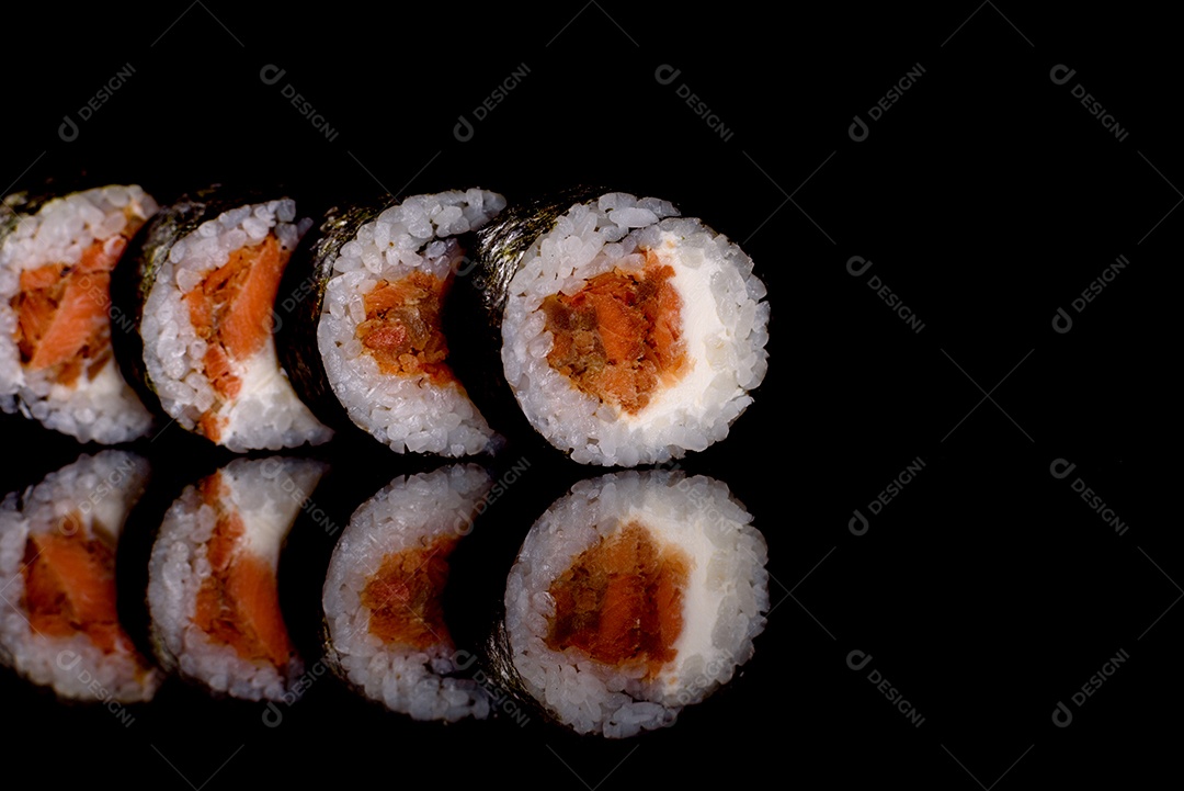 Rolos de sushi lindos e deliciosos frescos em um fundo escuro. Elementos da culinária japonesa