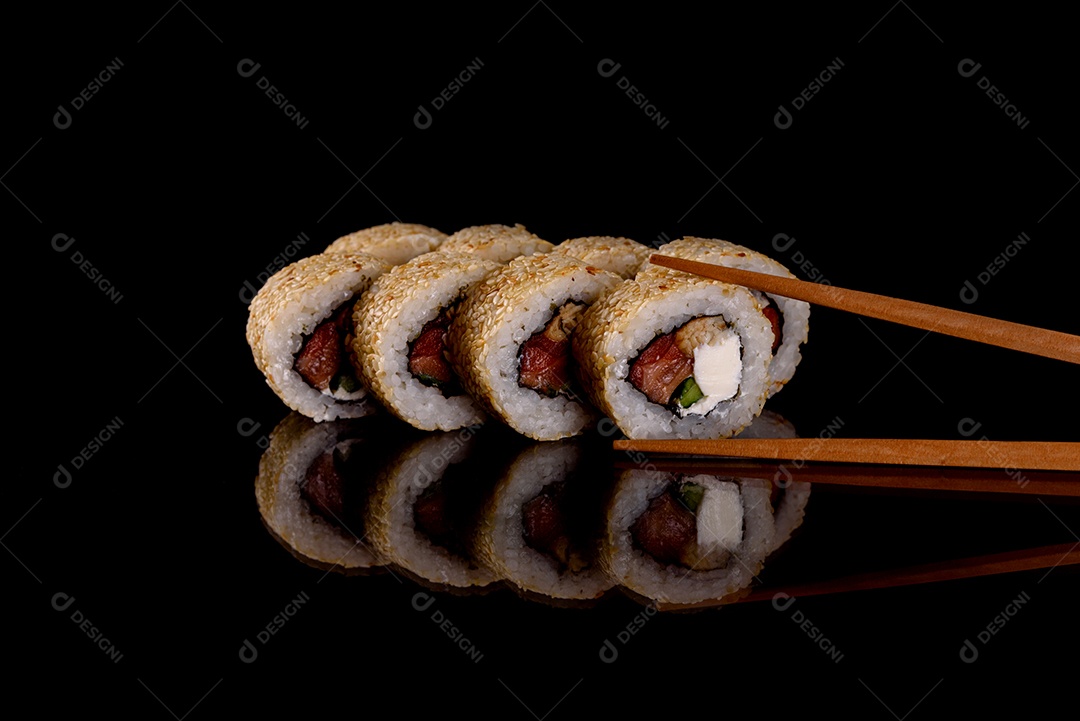 Rolos de sushi lindos e deliciosos frescos em um fundo escuro. Elementos da culinária japonesa