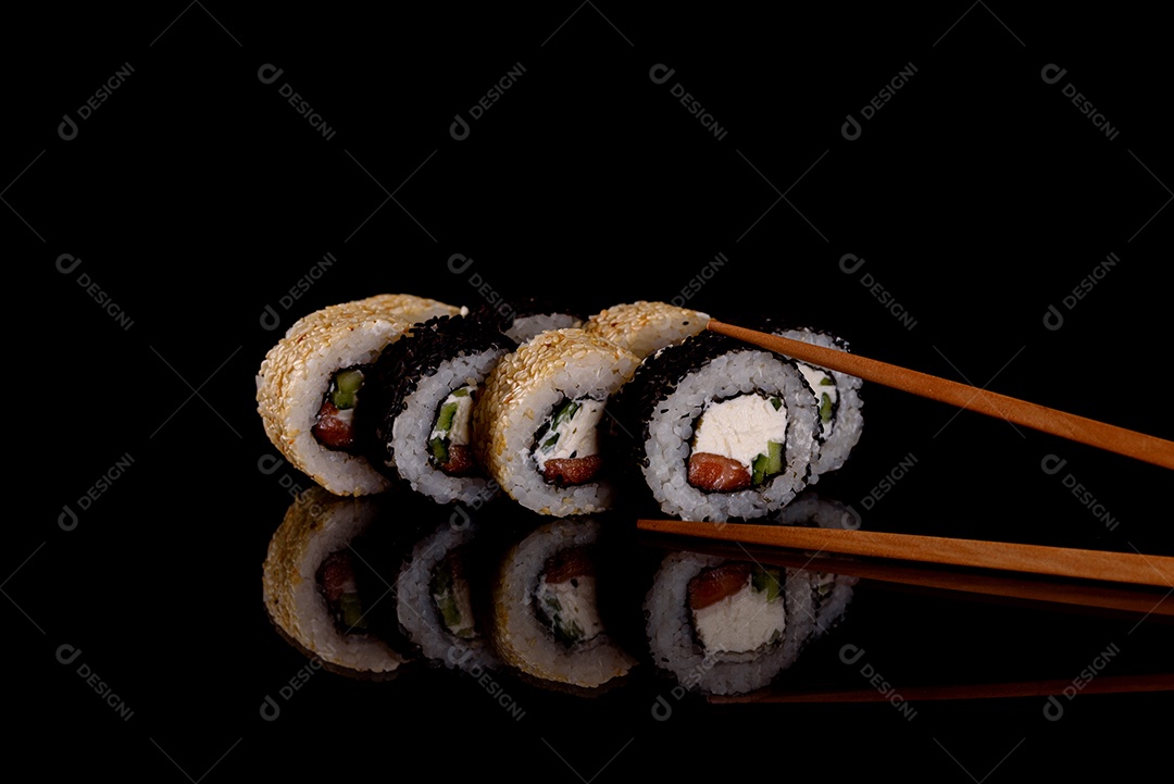 Rolos de sushi lindos e deliciosos frescos em um fundo escuro. Elementos da culinária japones