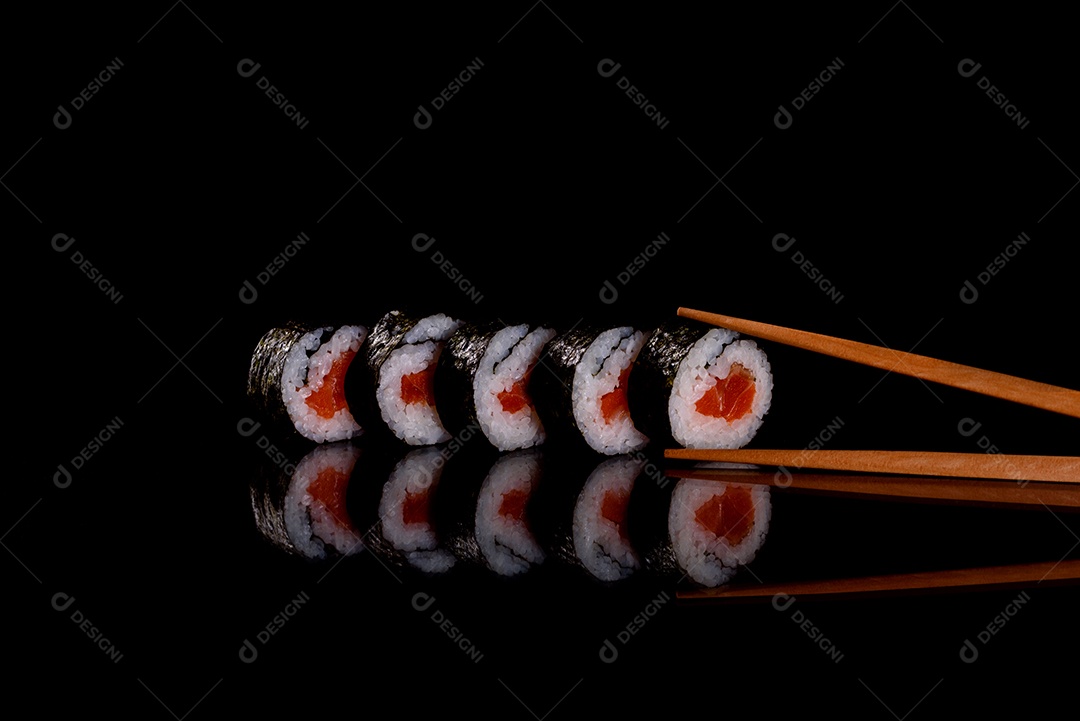 Rolos de sushi lindos e deliciosos frescos em um fundo escuro. Elementos da culinária japonesa