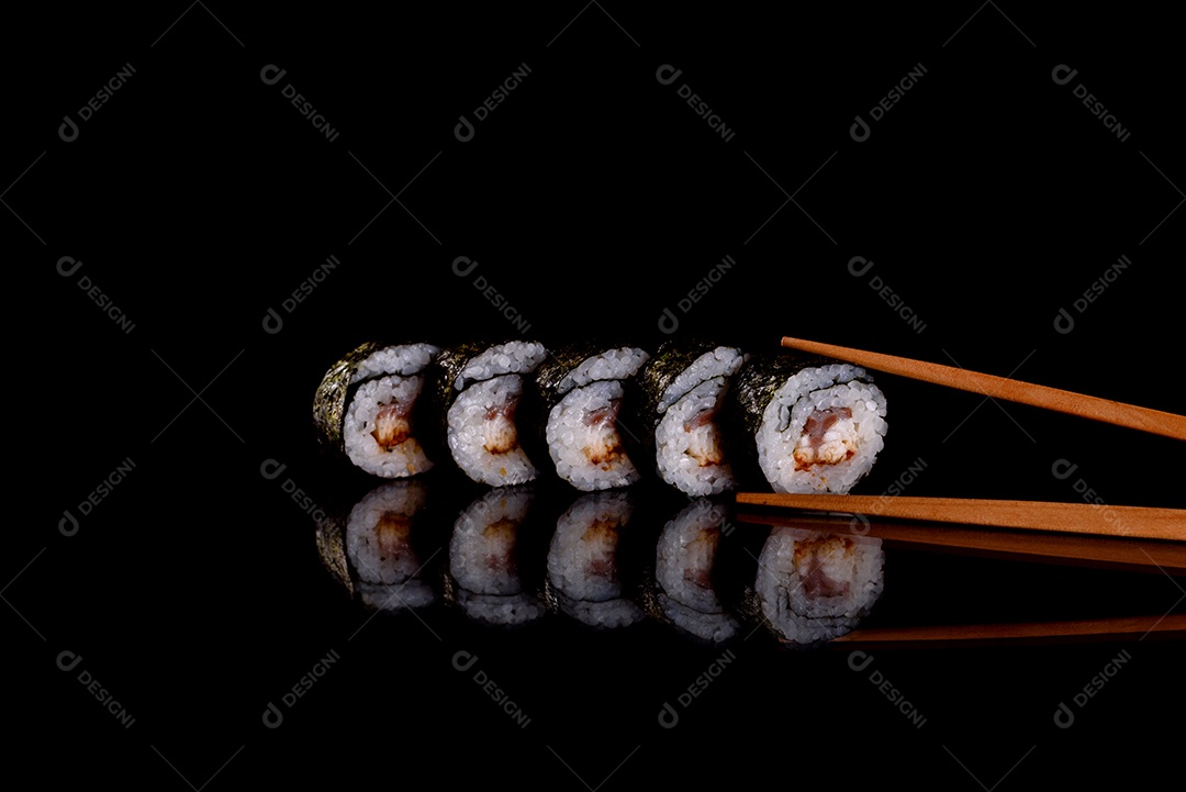 Rolos de sushi lindos e deliciosos frescos em um fundo escuro. Elementos da culinária japonesa