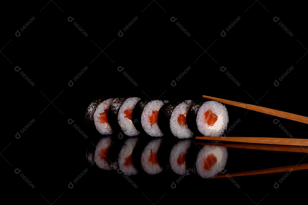 Rolos de sushi lindos e deliciosos frescos em um fundo escuro. Elementos da culinária japonesa