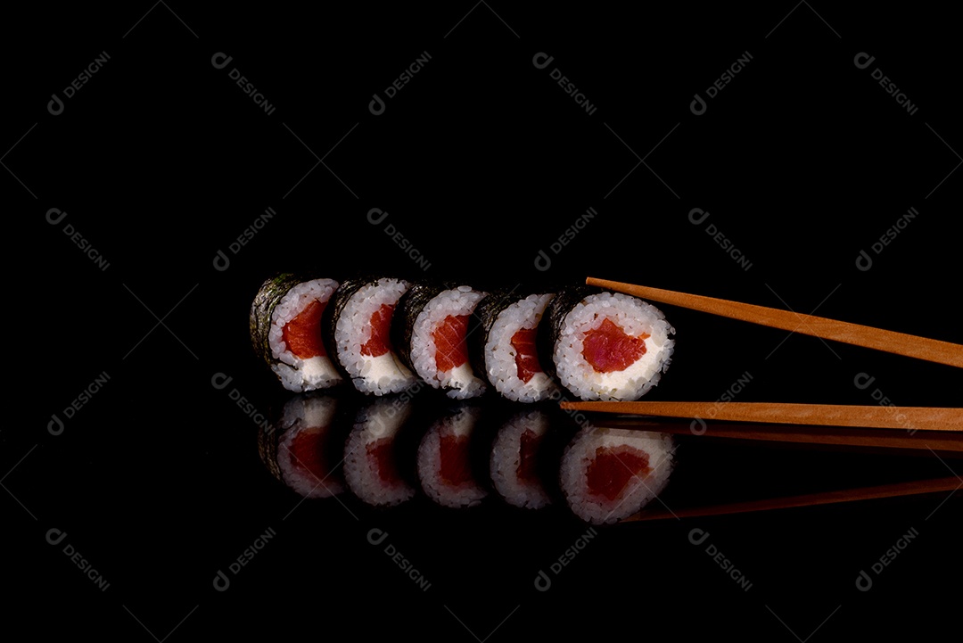 Rolos de sushi lindos e deliciosos frescos em um fundo escuro. Elementos da culinária japonesa