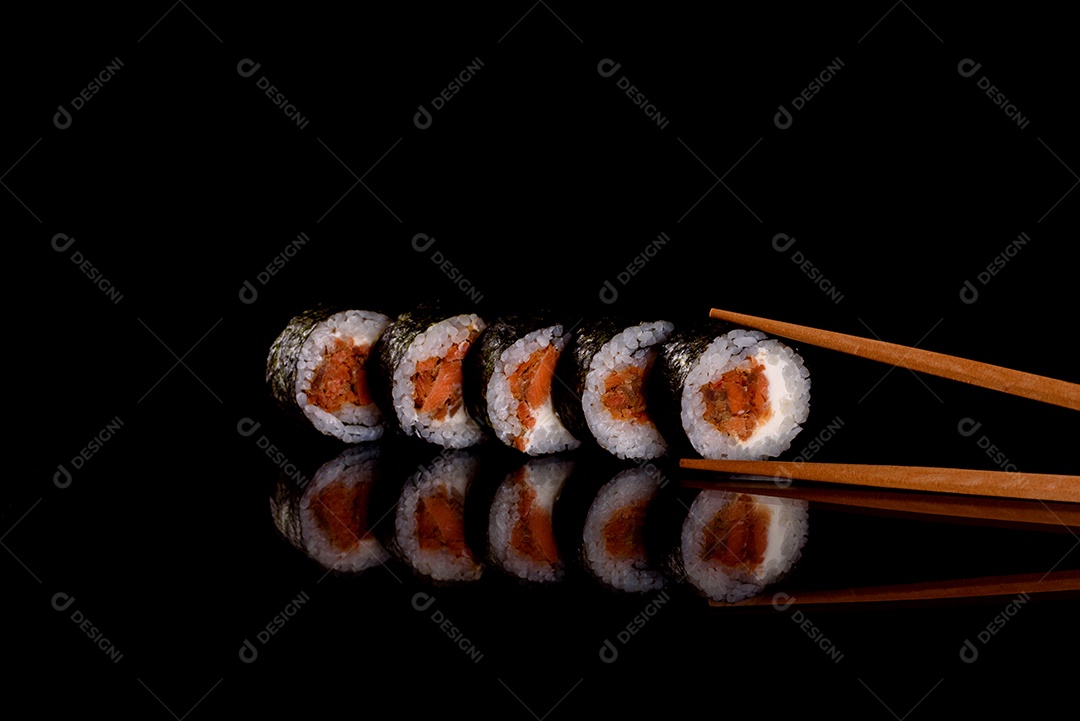 Rolos de sushi lindos e deliciosos frescos em um fundo escuro. Elementos da culinária japonesa