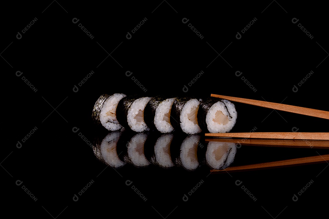 Rolos de sushi lindos e deliciosos frescos em um fundo escuro. Elementos da culinária japonesa