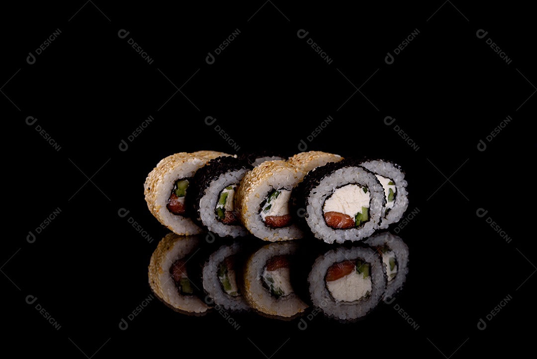 Rolos de sushi lindos e deliciosos frescos em um fundo escuro. Elementos da culinária japonesa
