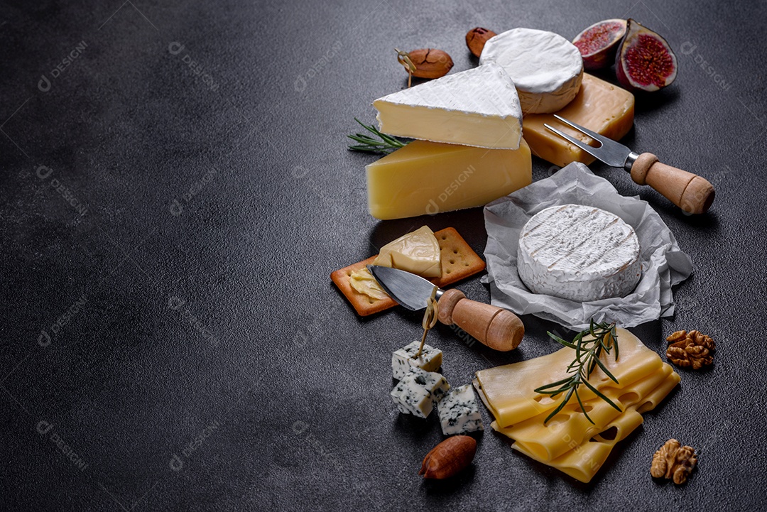 Lindo delicioso queijo camembert, parmesão, brie com uvas e figos em uma tábua de madeira.