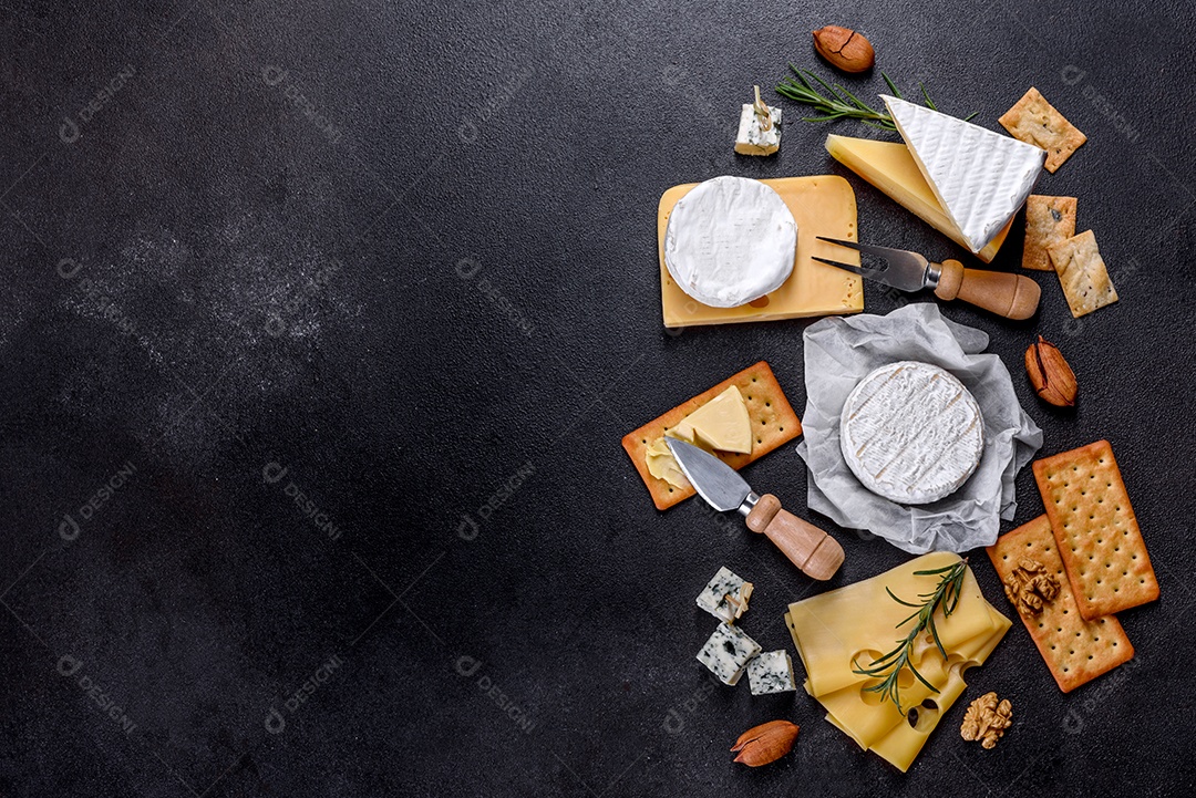 Lindo delicioso queijo camembert, parmesão, brie com uvas e figos em uma tábua de madeira.