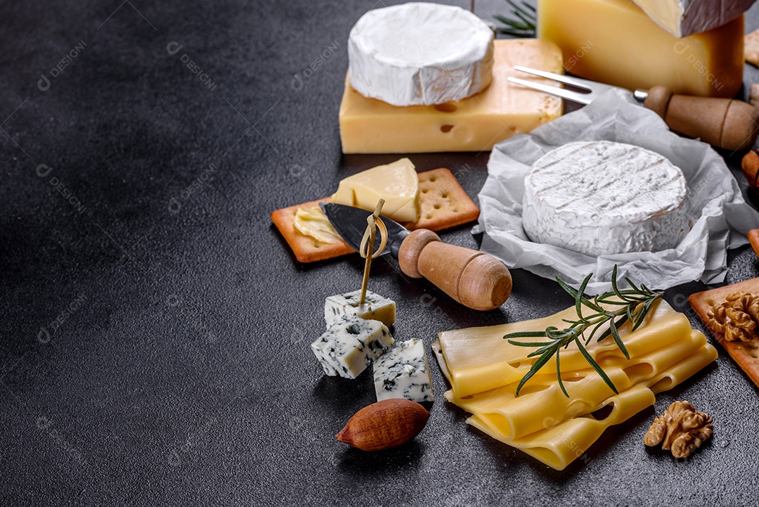 Lindo delicioso queijo camembert, parmesão, brie com uvas e figos em uma tábua de madeira.