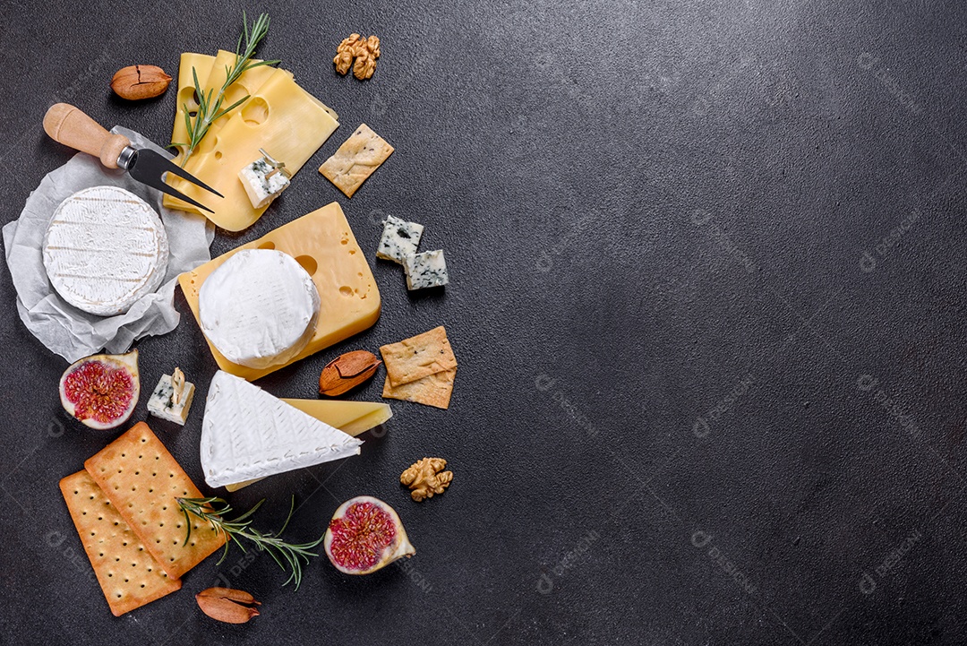 Lindo delicioso queijo camembert, parmesão, brie com uvas e figos em uma tábua de madeira.