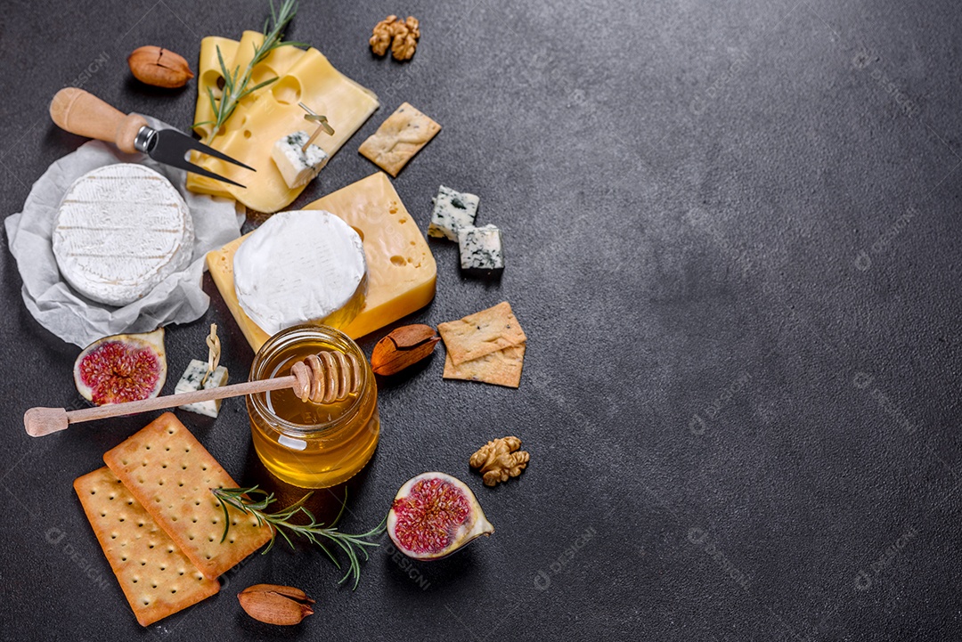 Lindo delicioso queijo camembert, parmesão, brie com uvas e figos em uma tábua de madeira.