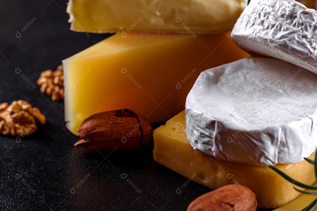 Lindo delicioso queijo camembert, parmesão, brie com uvas e figos em uma tábua de madeira.