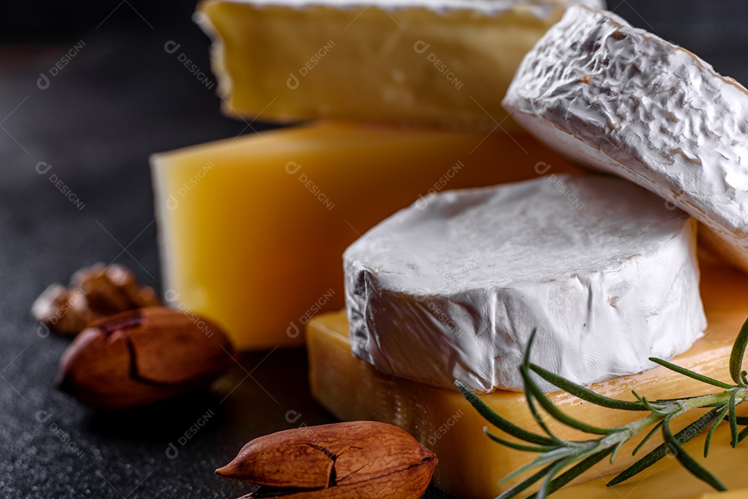 Lindo delicioso queijo camembert, parmesão, brie com uvas e figos em uma tábua de madeira.