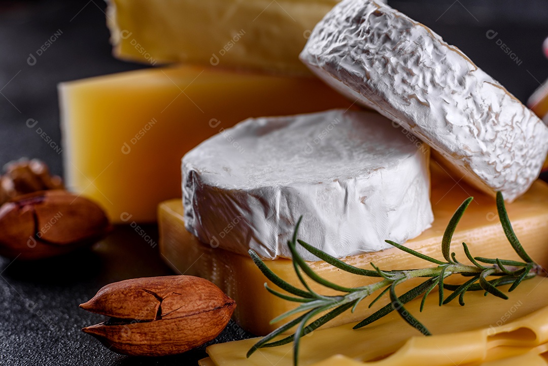 Lindo delicioso queijo camembert, parmesão, brie com uvas e figos em uma tábua de madeira.