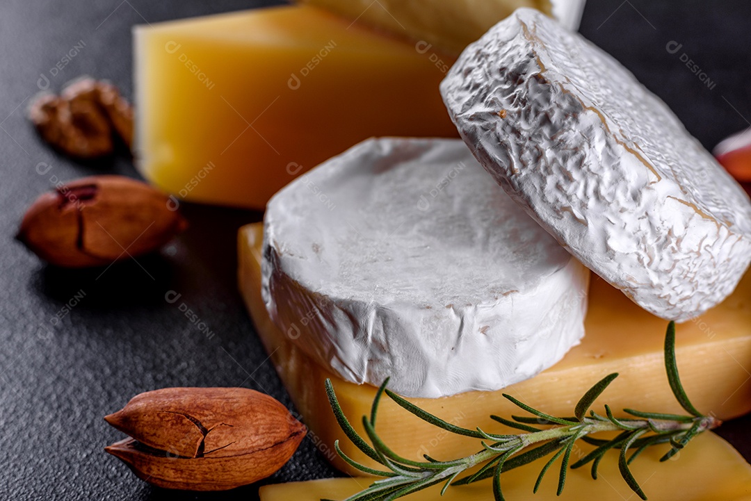 Lindo delicioso queijo camembert, parmesão, brie com uvas e figos em uma tábua de madeira.