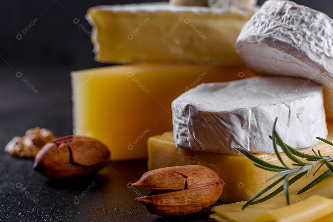Lindo delicioso queijo camembert, parmesão, brie com uvas e figos em uma tábua de madeira.
