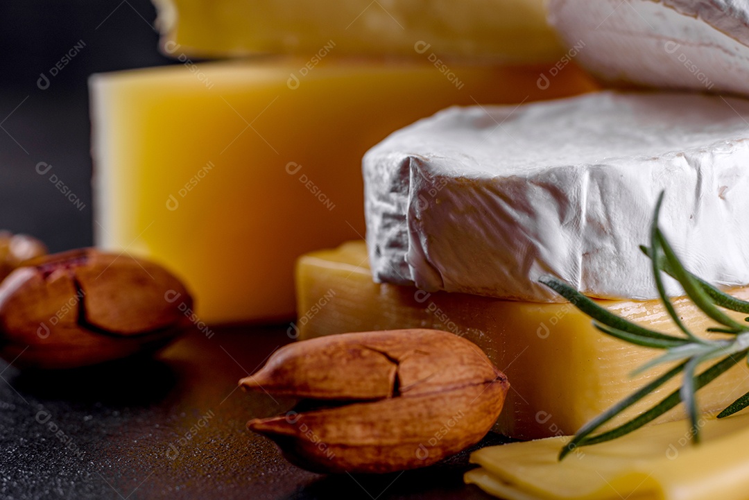 Lindo delicioso queijo camembert, parmesão, brie com uvas e figos em uma tábua de madeira.