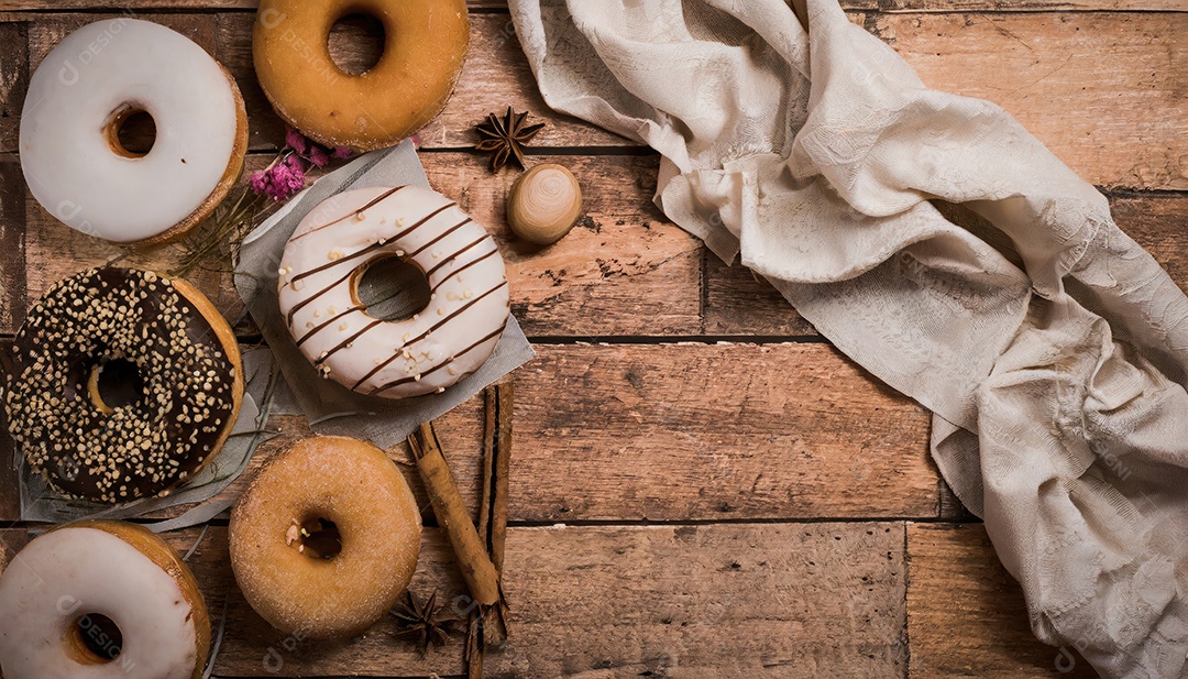 Variedade de donuts sobre um fundo rústico.