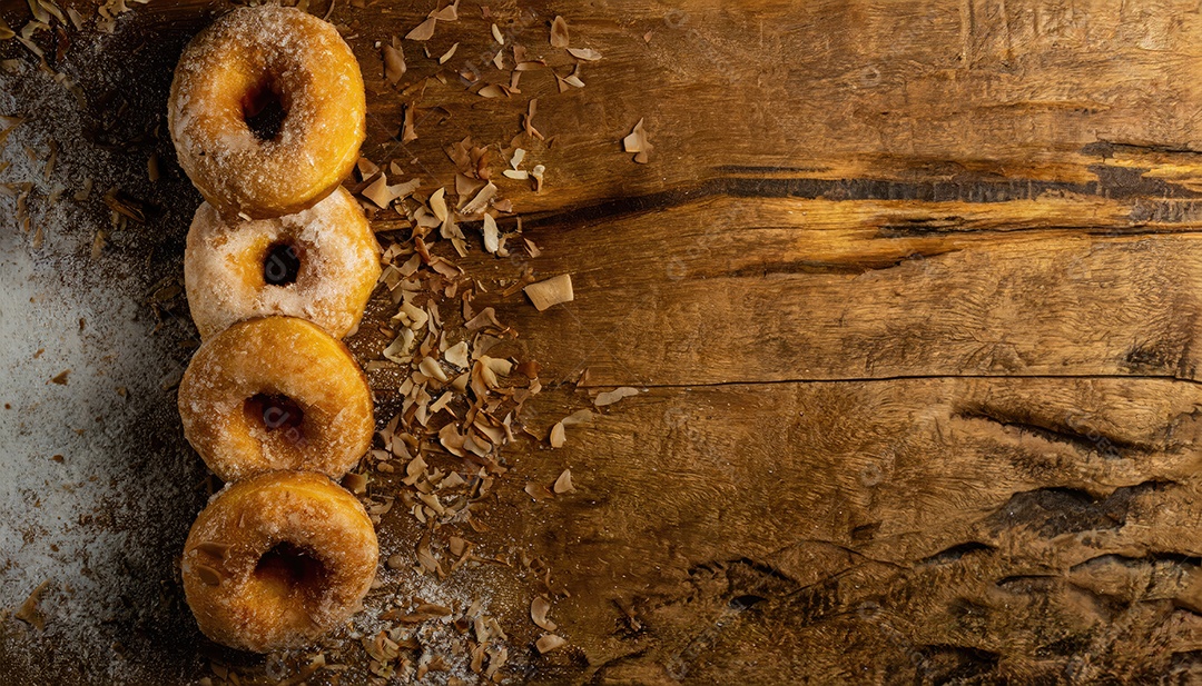 Donuts com açúcar de confeiteiro na mesa de madeira,