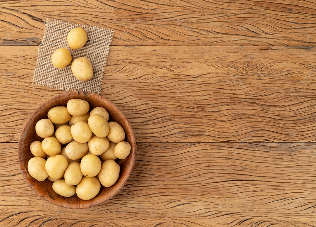 Pequenas batatas em uma tigela sobre a mesa de madeira