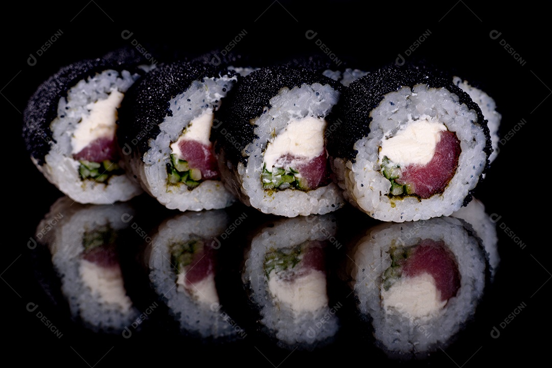 Rolos de sushi lindos e deliciosos frescos em um fundo escuro. Elementos da culinária japonesa