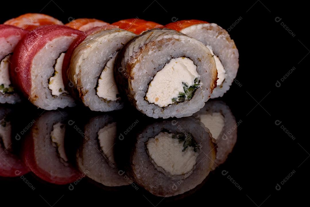 Rolos de sushi lindos e deliciosos frescos em um fundo escuro. Elementos da culinária japonesa