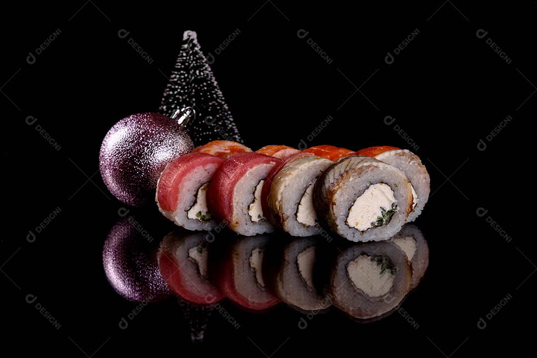 Rolos de sushi lindos e deliciosos frescos em um fundo escuro. Elementos da culinária japonesa