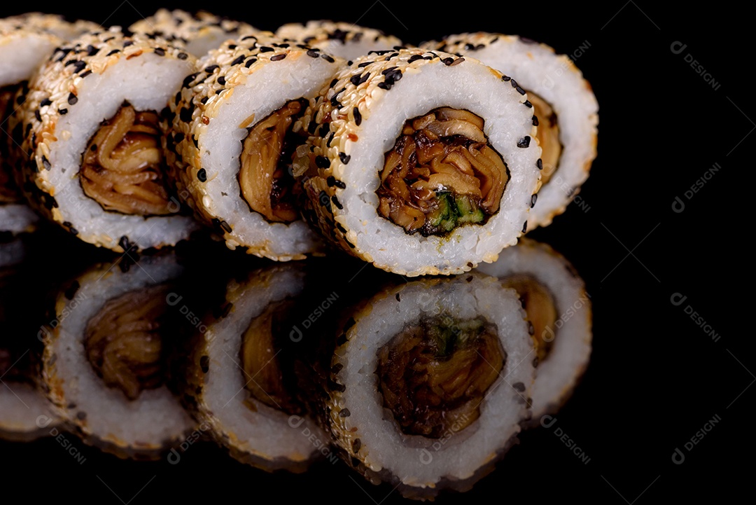 Rolos de sushi lindos e deliciosos frescos em um fundo escuro. Elementos da culinária japonesa