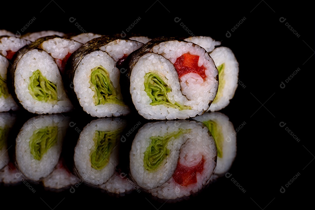 Rolos de sushi lindos e deliciosos frescos em um fundo escuro. Elementos da culinária japonesa