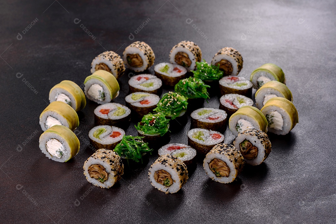 Rolos de sushi lindos e deliciosos frescos em um fundo escuro. Elementos da culinária japonesa