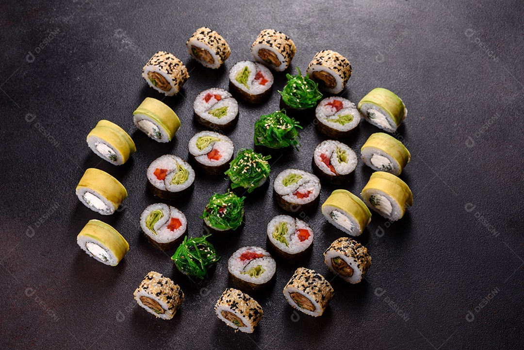 Rolos de sushi lindos e deliciosos frescos em um fundo escuro. Elementos da culinária japonesa
