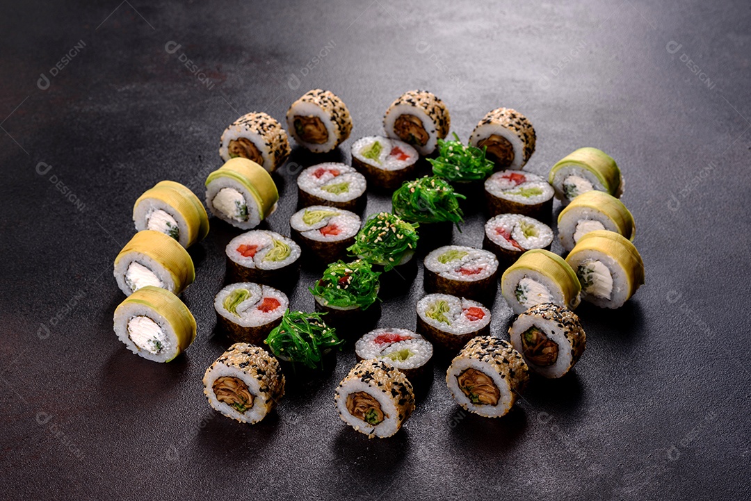 Rolos de sushi lindos e deliciosos frescos em um fundo escuro. Elementos da culinária japonesa