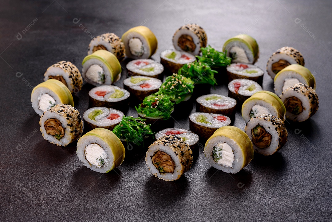 Rolos de sushi lindos e deliciosos frescos em um fundo escuro. Elementos da culinária japonesa