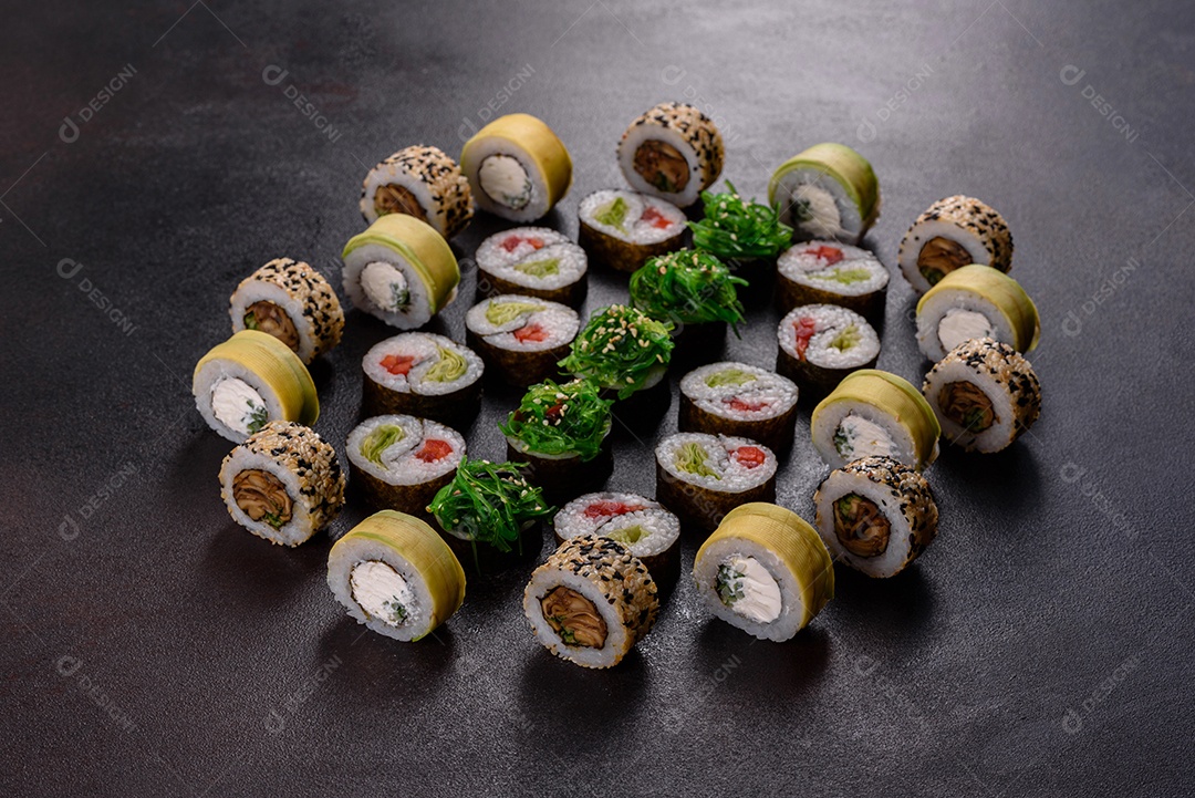Rolos de sushi lindos e deliciosos frescos em um fundo escuro. Elementos da culinária japonesa