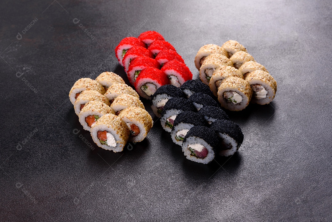 Rolos de sushi lindos e deliciosos frescos em um fundo escuro. Elementos da culinária japonesa