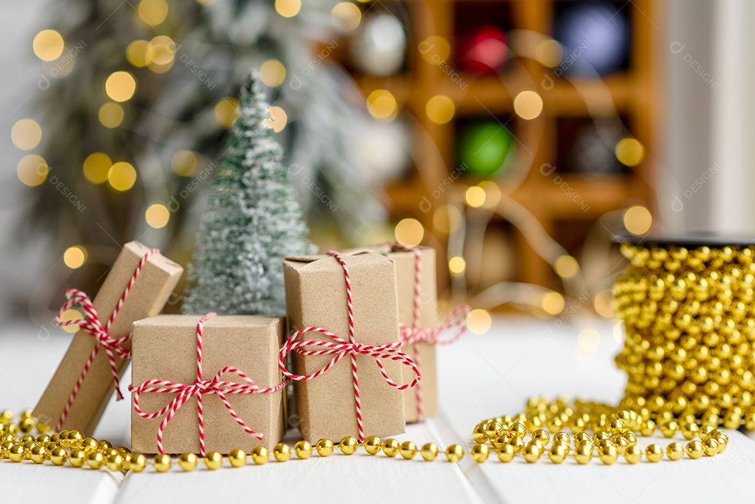 Lindas decorações de Natal multicoloridas sobre uma mesa de madeira clara com guirlandas e árvores de Natal ao fundo.