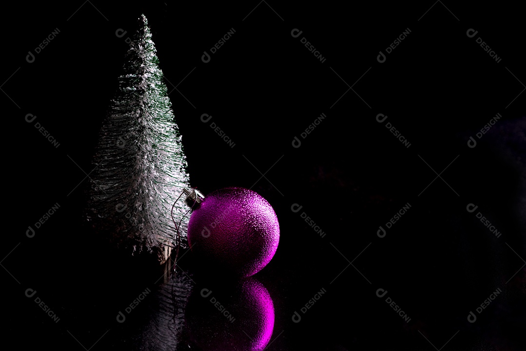 Árvore de Natal festiva e outros itens da mesa de Natal em um fundo preto.