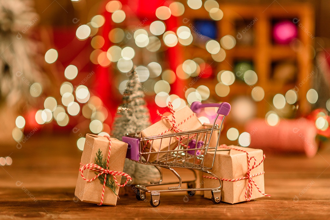 Lindas decorações de Natal multicoloridas em uma mesa de madeira com guirlandas e árvores de Natal ao fundo.