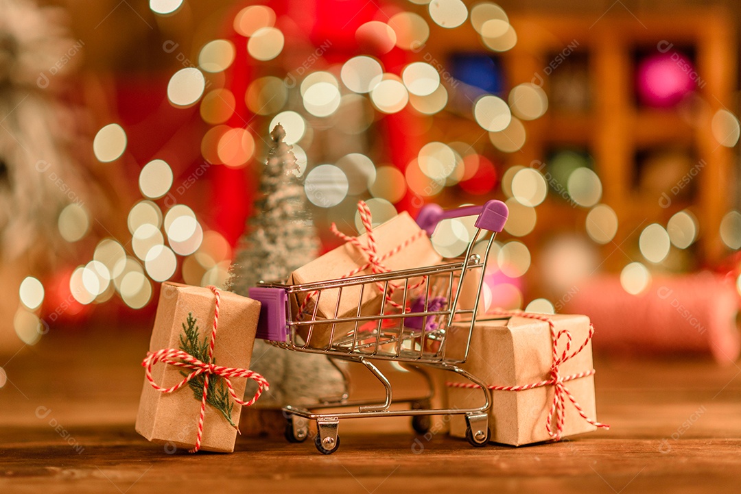 Lindas decorações de Natal multicoloridas em uma mesa de madeira com guirlandas e árvores de Natal ao fundo.