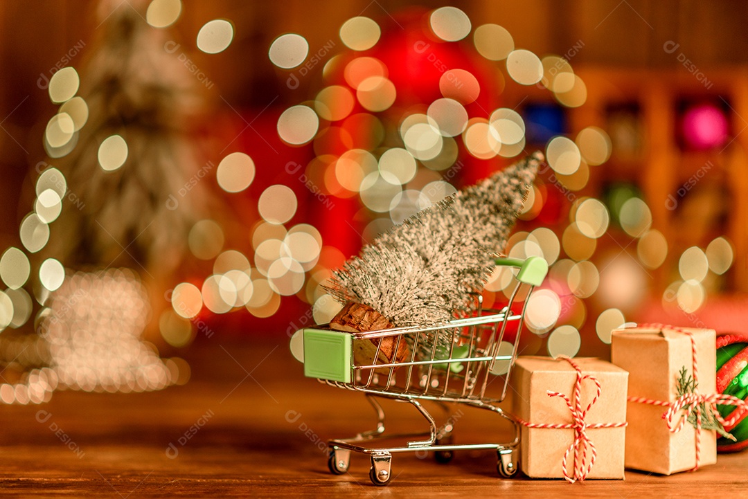 Lindas decorações de Natal multicoloridas em uma mesa de madeira com guirlandas e árvores de Natal ao fundo.