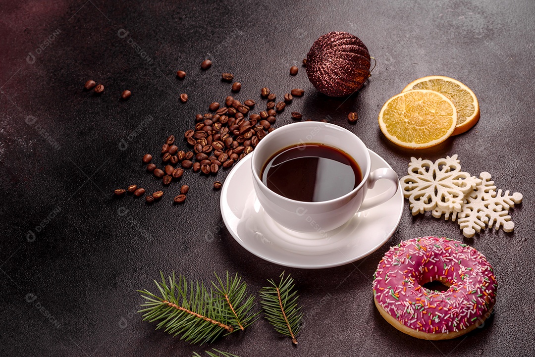 Uma xícara de café forte na mesa de Natal com galhos de abeto e brinquedos.