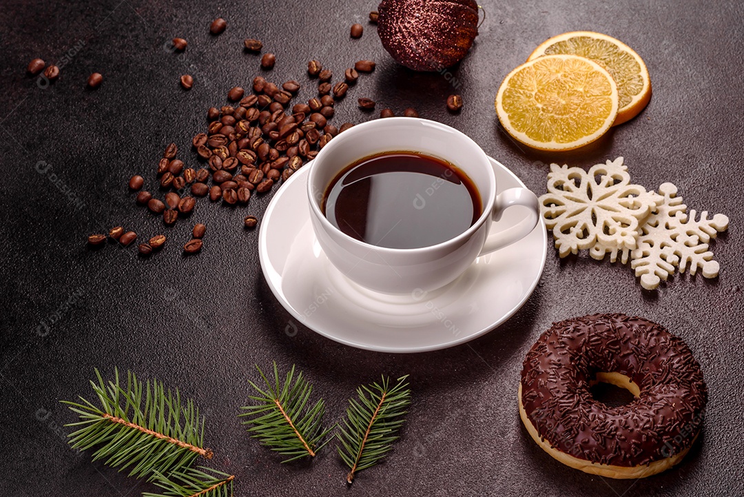 Uma xícara de café forte na mesa de Natal com galhos de abeto e brinquedos.