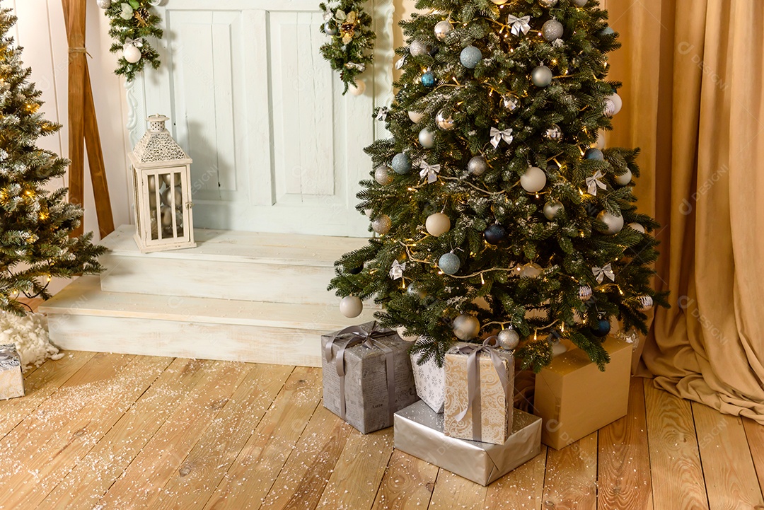 Lindo quarto decorado com árvore de Natal com presentes debaixo dela.